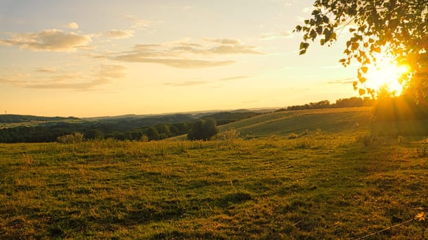 hilly landscape in the saarland. sunset on a meadow with view into the valley. interesting light atmosphere, colorful and beautiful