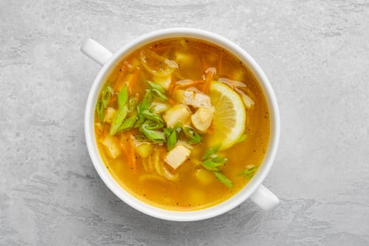 Top view of vegetable and fish soup with fresh scallions