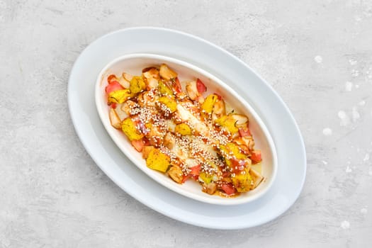Overhead view of hot casserole with chicken, pumpkin, bell pepper and potatoes