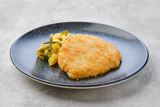 Pork schnitzel with potato and pickled cucumber in mustard sauce