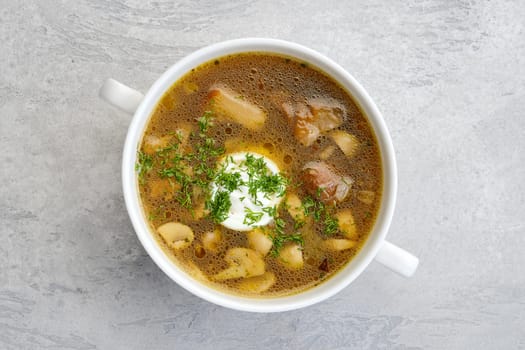 Top view of mushrooms and potato soup with sour cream