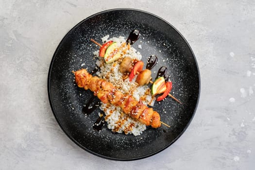 Top view of shashlik with chicken and grilled champignon with bell pepper and zucchini served with boiled rice