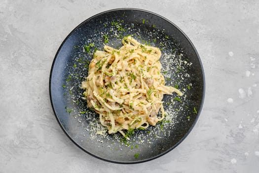 Top view of pasta with honey agarics, onion and cheese on a plate