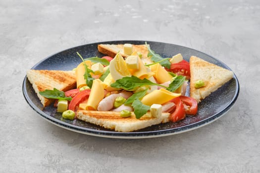 Triangular pieces of toast, ham, boiled egg, cheddar and tomato