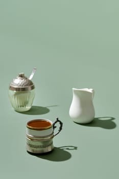 Coffee concept - cup of coffee, milk pot and shugar (focus on foreground)