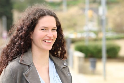 Beautiful woman with curly hair looking at camera in a park