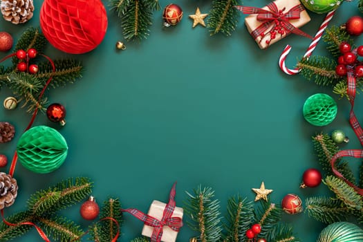 Border made of Wrapped gift boxes, Christmas decorations and green fir branches top view on green background, copy space. Christmas or New Year Holiday atmosphere flat lay