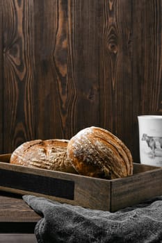 Two loafs of artisan whole grain wheat bread on wooden table