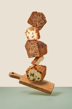 Stacked pieces of biscuit cupcakes. Balancing cakes on wooden board