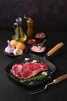 Raw ribeye steak, premium beef boneless meat on cast-iron pan