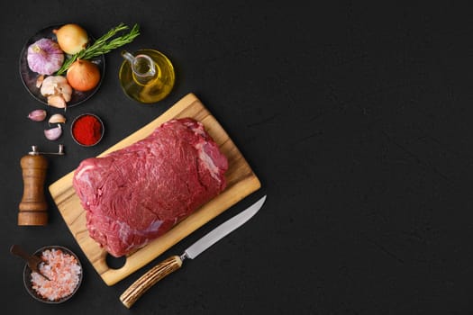 Overhead view of raw chuck eye roast with ingredients for cooking