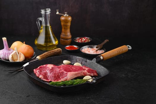 Raw ribeye steak, premium beef boneless meat on cast-iron pan