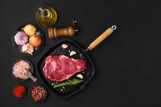 Overhead view of raw ribeye steak, premium beef boneless meat on cast-iron pan