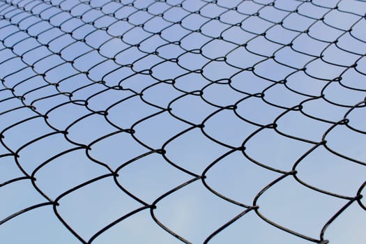 Metal mesh close-up against the blue sky. The concept of freedom and peace.