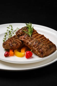 Two grilled steaks on a plate closeup view