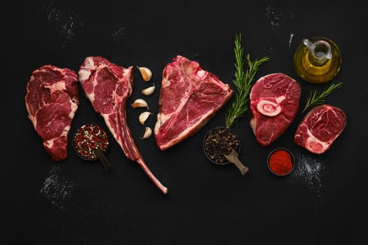 Overhead composition with raw prime beef cuts - porter house, cowboy steak, ossobuco, ribeye and tri-tip roast