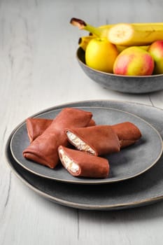Thin chocolate pancakes stuffed with ricotta, banana and apple