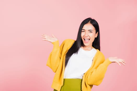 Happy Asian portrait beautiful cute young woman standing winning and surprised excited screaming open mouth raise hands, studio shot isolated pink background, Thai female wow with copy space