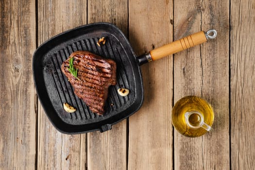 Overhead view of chuck eye steak fried on cast iron grill pan