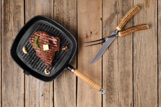 Overhead view of chuck eye steak fried on cast iron grill pan