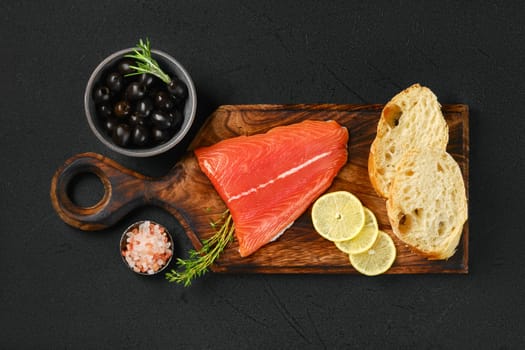 Top view of piece of fresh salmon tail fillet with ciabatta and spicy herb sauce