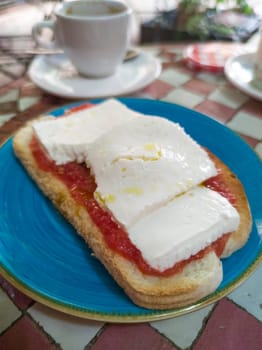 Cottage cheese and tomato toast over glazed tile mosaic table. Arabic style background