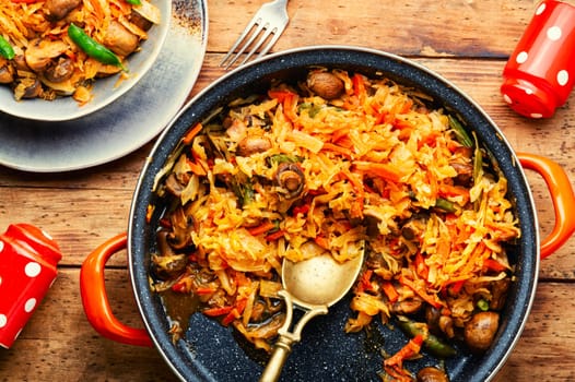 Cabbage stewed with mushrooms and carrots. Lenten food. Copy space, recipe place