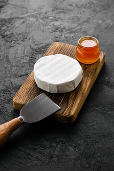 Piece of soft brie or camembert cheese on cutting board