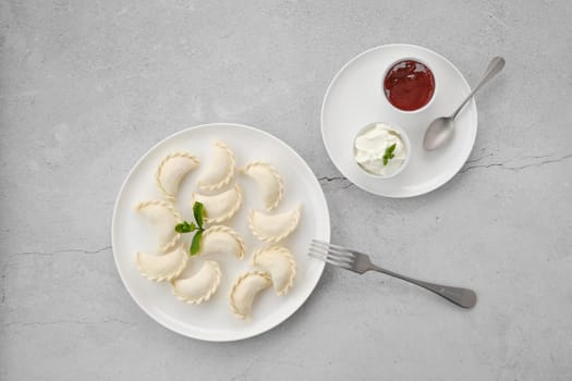 Frozen semifinished vareniki stuffed with cherry on grey background