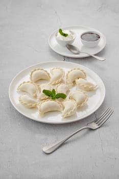 Frozen semifinished vareniki stuffed with cherry on grey background