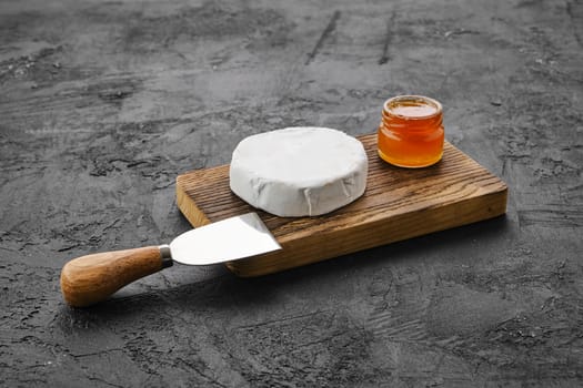 Piece of soft brie or camembert cheese on cutting board