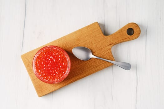 Overhead view of open pot with pink salmon red caviar