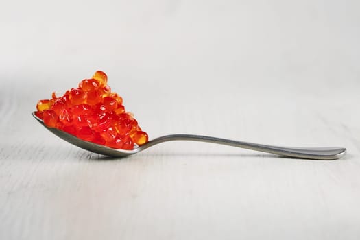 Spoon with salmon red caviar.