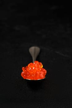 Spoon with salmon red caviar (photo with shallow depth of field)