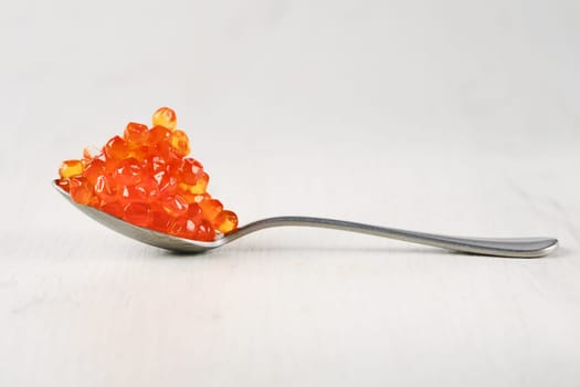 Spoon with salmon red caviar.