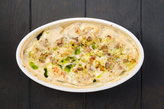 Overhead view of chicken dumplings with spicy onion sauce baked in oven