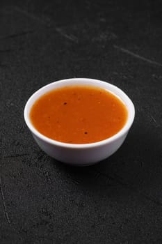 Small bowl with spicy orange sauce for poultry