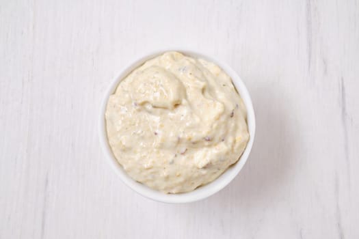 Overhead view of small bowl with caesar sauce for salad