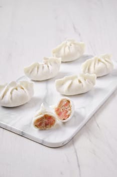 Frozen dumplings stuffed with liver and provencal herbs on marble serving plate