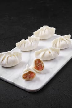 Frozen dumplings stuffed with liver and provencal herbs on marble serving plate