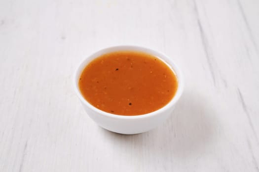 Small bowl with spicy orange sauce for poultry