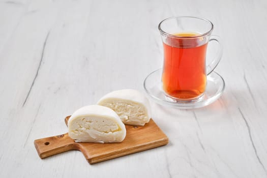 Sweet dessert mochi with coconut chips cut on half with fruit tea