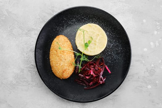 Kiev citlet with mashed potato and pickled beetroot on a plate, top view