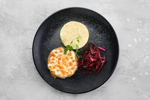 Kiev citlet with mashed potato and pickled beetroot on a plate, top view