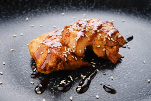 Fried chicken meat with teriyaki sauce on a plate, closeup view