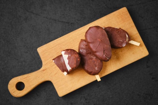 Top view of homemade curd bars in chocolate on wooden board (soft focus photo)