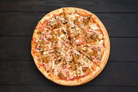Pizza with bacon, ham, champignon and fried onion, top view