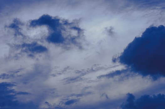 Dark clouds in blue sky background. Dark Rain clouds floating in sunset sky. Nature background.