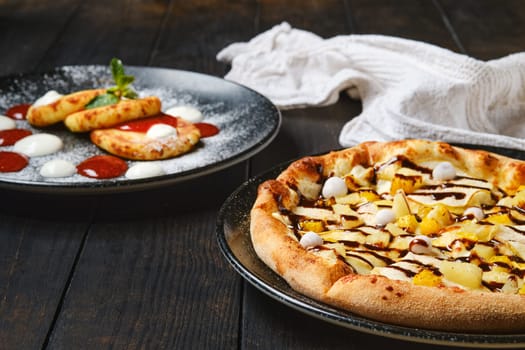 Sweet pie with banana, orange, cranberry in powdered sugar and caramel syrup