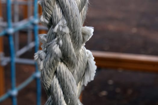 Worn gray rope close-up on a children's playground in a city park.